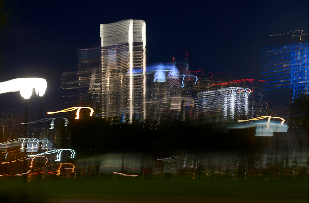 The lights of the nighttime city skyline of Philadelphia are shown with a motion blur.